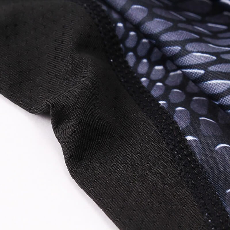 Close-up of men's compression top with snake skin 3D print and black seam, highlighting breathable polyester fabric.